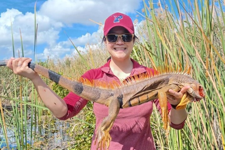 a young boy standing next to a body of water