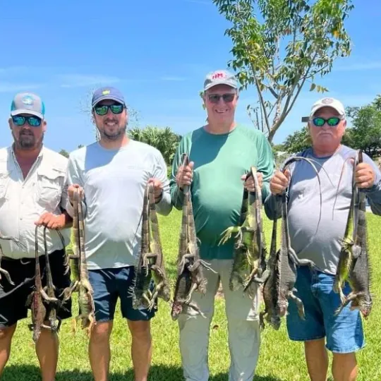 a group of people standing in a grass field posing for the camera
