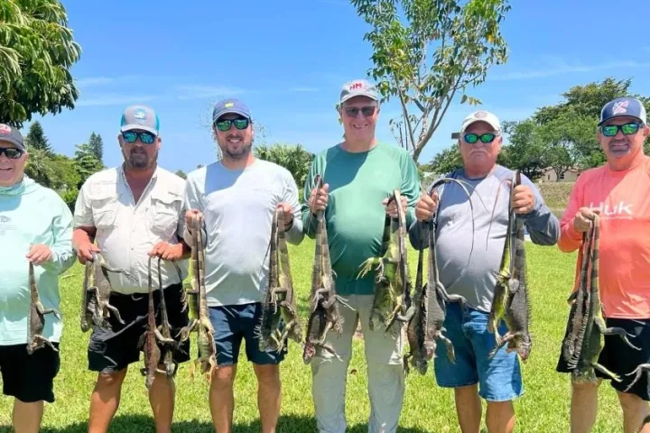 a group of people standing in a grass field posing for the camera